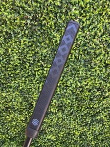 Close up of STIX putter grip laying on grass.